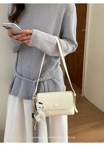 Dettaglio borsa a tracolla minimalista squisita, stile retro elegante, bianco crema.