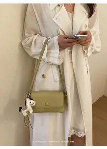 Elegante borsa a spalla verde con ciondolo cavallo, design retrò minimalista chic.