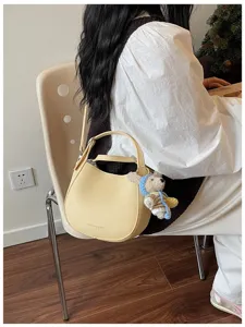 Sac bandoulière chic en cuir jaune pour femme, sac à main minimaliste et élégant.