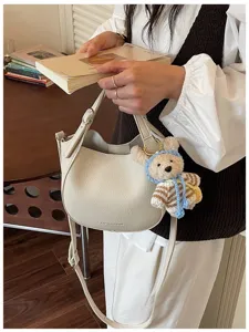 Vue détaillée du sac seau tendance en similicuir avec charm d'ours en peluche doux.