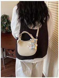 Vue détaillée du sac à bandoulière demi-lune décontracté pour femme avec adorable pendentif.