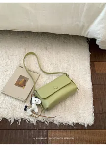 Borsa a tracolla verde pallido minimalista con ciondolo cavallo per outfit quotidiani.