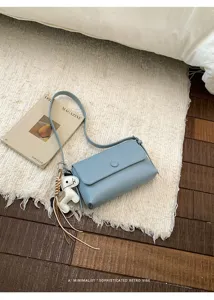 Elegante borsa a tracolla azzurro chiaro con ciondolo a cavallo e design retrò minimalista.