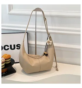 Beige Hobo Schultertasche Detailansicht, lässige Dumpling Umhängetasche mit Gurt und Anhänger.