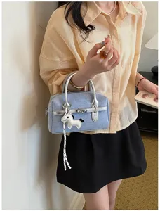 Stylish denim handbag with silver handles and cute charm, perfect for summer daily commuting.