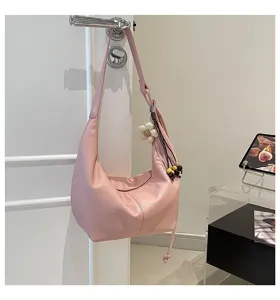 Detailansicht der rosafarbenen Schultertasche aus Leder mit niedlichem Blumenanhänger.