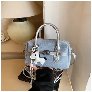 Chic denim boston bag for women, stylish silver contrast handles and cute horse charm detail.