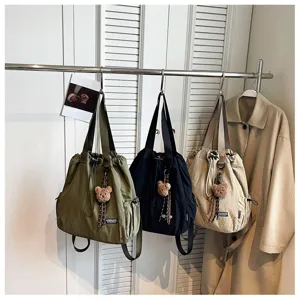 Details view of Korean fashion commuting bucket bag with large capacity and bear pendant.