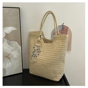 Detailansicht der Beigefarbenen Stroh Tragetasche mit Anhänger, geräumige Schultertasche.