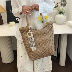 Modische geflochtene Strohtasche für Damen, große Handtasche mit elegantem Quastenanhänger.