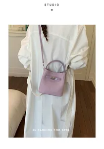 Stylish purple woven bucket bag with metal lock, chic shoulder crossbody bag for women.