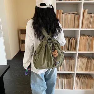 Green canvas drawstring backpack casual large capacity daily shoulder bag with cute bear charm.