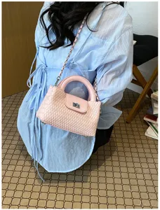 Pink woven leather handbag detail showcasing intricate texture and chic chain strap design.