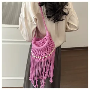 Gedetailleerd overzicht van roze macramé schoudertas met houten kralen en franjes.