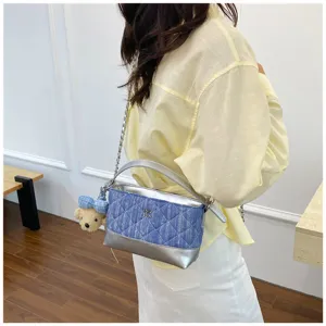 Elegante borsa a tracolla trapuntata in denim con finiture metalliche argentate e ciondolo.