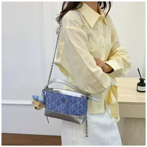 Elegante borsa a tracolla in denim trapuntato da donna con catena e grazioso ciondolo a orsetto.