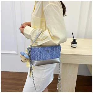 Vista dettagliata della borsa a tracolla in denim trapuntato con pelle e ciondolo.