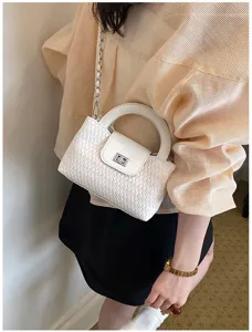 Close-up detail shot of the elegant white woven crossbody bag showcasing texture and chain strap.