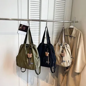 Casual canvas drawstring bucket bag convertible backpack with cute bear pendant for daily commute.