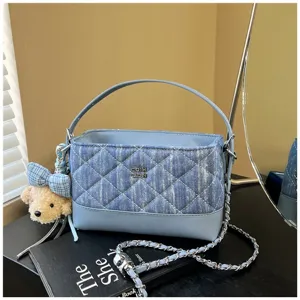 Borsa a tracolla trapuntata in denim blu con catena elegante e ciondolo orsetto.