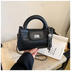 Black woven leather handbag detail, top handle and metal chain strap for stylish look.