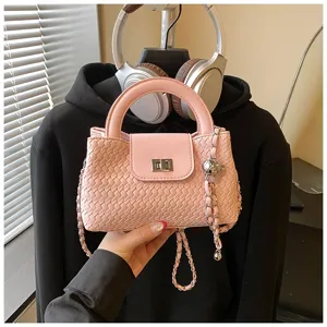 Pink woven detail crossbody bag featuring leather handle, metal turn lock and chain strap.