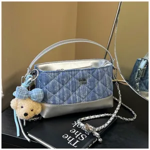 Chic borsa a tracolla in denim trapuntato con manico argentato, catena e simpatico ciondolo.