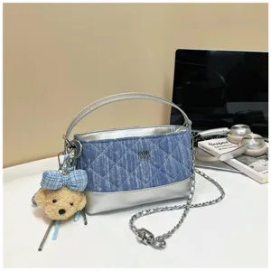 Borsa a tracolla trapuntata in denim chic con fondo metallico argentato e ciondolo orsetto.