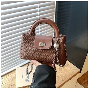 Brown woven top handle crossbody bag for women with chic chain strap and metal lock closure.