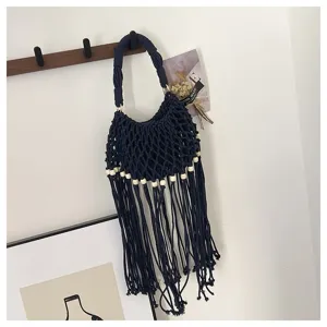 Detailopname van een handgemaakte donkerblauwe macramé geweven handtas met franjes en kralen.