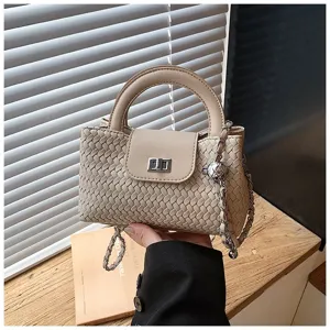 Detailed view of a chic beige woven handbag featuring top handle and stylish chain strap.