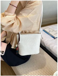 Détail de sac seau tissé blanc montrant une texture complexe et une scène de style de vie.