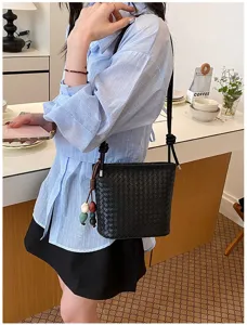Vue détaillée du sac seau en cuir tressé noir avec perles suspendues, sac bandoulière élégant chic.