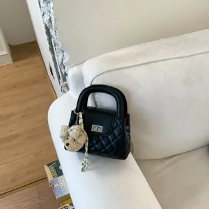 Klassieke zwarte gewatteerde handtas met schattige berenhanger, chique mini modetas.