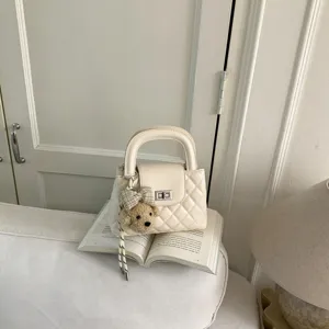 Crèmekleurige gewatteerde handtas met schattige berenhanger en draaisluiting voor dames.