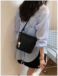 Détail chic de sac seau tressé noir, élégant sac à bandoulière tendance pour femme.