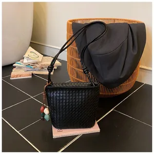 Sac seau tressé noir pour femme, sac à bandoulière élégant en cuir de style.
