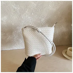 Vue détail sac bandoulière tressé, sac smartphone en cuir blanc avec sangle élégante.