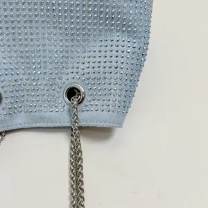 Detalle de bolso de hombro con pedrería brillante, elegante cadena plateada y diseño chic.