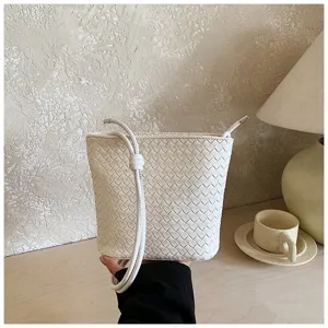 Vue détaillée du sac seau tressé blanc, élégant sac bandoulière avec texture en cuir.