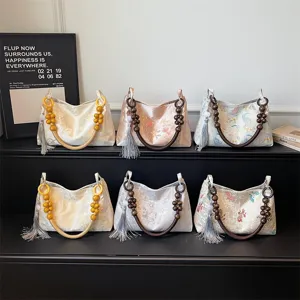 Chinese style brocade shoulder bag with wooden bead handle and tassel for women.