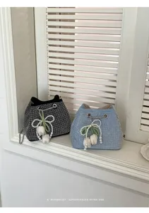 Detalle del bolso tipo bombonera de estrás brillante con colgante de perla y tulipán.