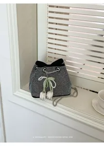 Bolso cubo negro de pedrería con cadena y un elegante colgante de tulipán de perla.