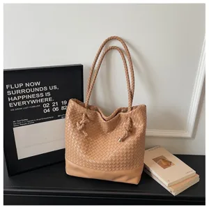 Détail de sac bandoulière en cuir tissé main, design camel élégant avec détails de nœuds chics.