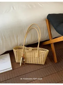 Vista detallada del bolso tote tejido informal con diseño calado y abalorio elegante.