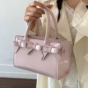 Borsa a mano in pelle verniciata rosa con fiocco da donna, borsa a tracolla chic ed elegante.