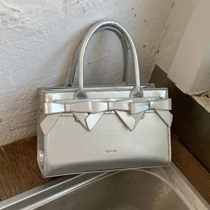 Borsa a mano da donna argentata ed elegante con fiocco, borsa a tracolla versatile estiva.
