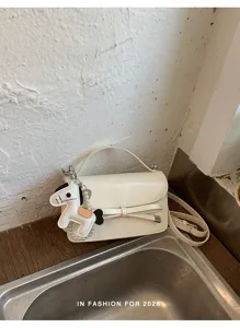 Bolso cruzado blanco elegante con lazo y dije de caballo con perlas para un estilo genial.