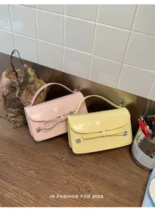 Primer plano detallado del elegante bolso de charol con lazo, bolso bandolera de tendencia en colores.