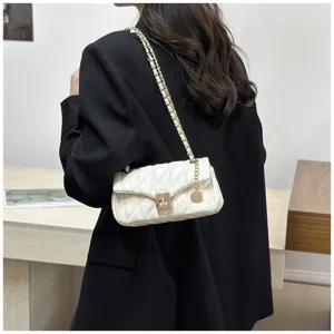 Dettaglio di una elegante borsa a tracolla trapuntata bianca, accessorio chic e moderno.